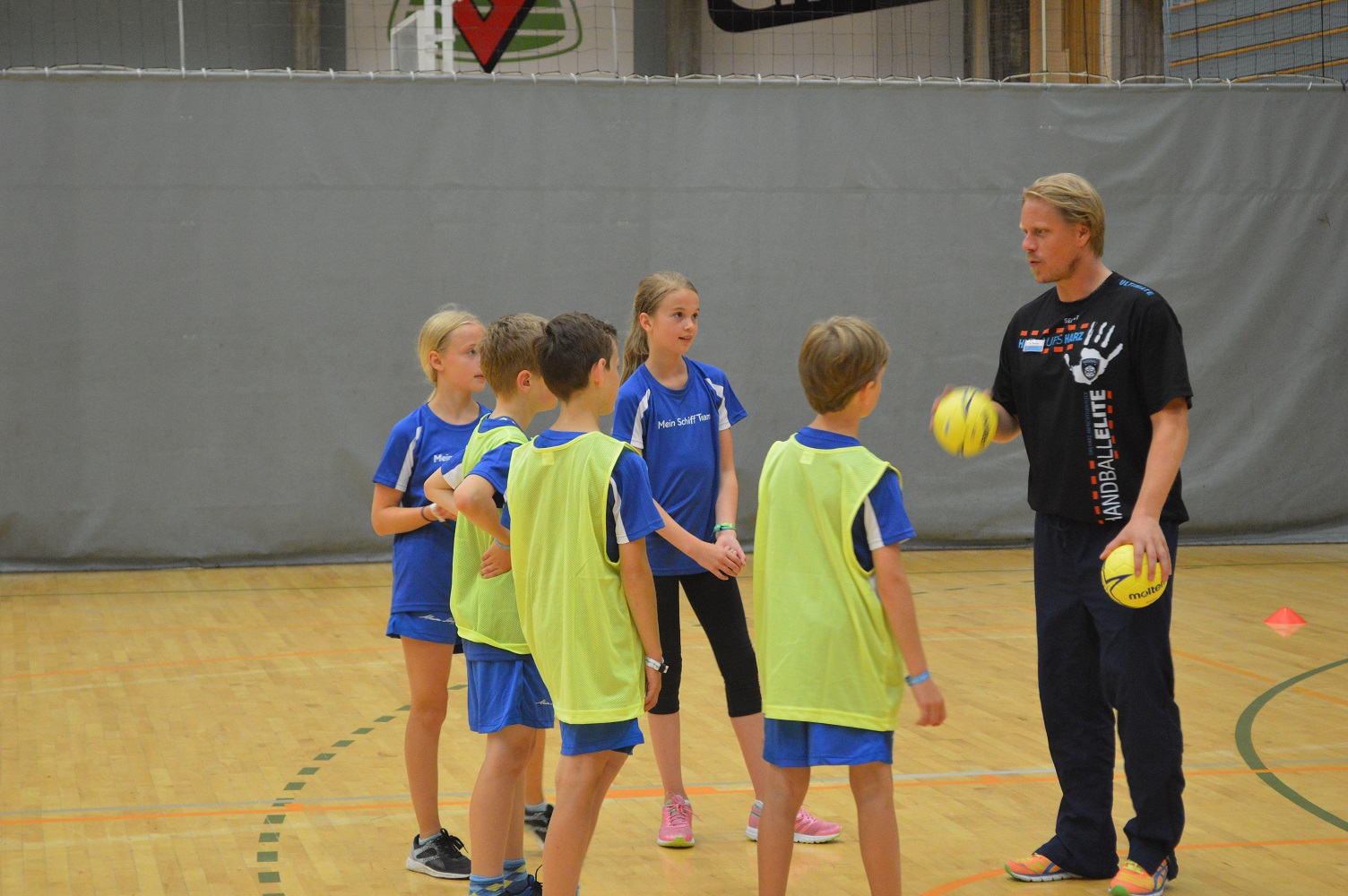 Handballtrainer Timo Lehberger erklärt den Kids Wurftechniken